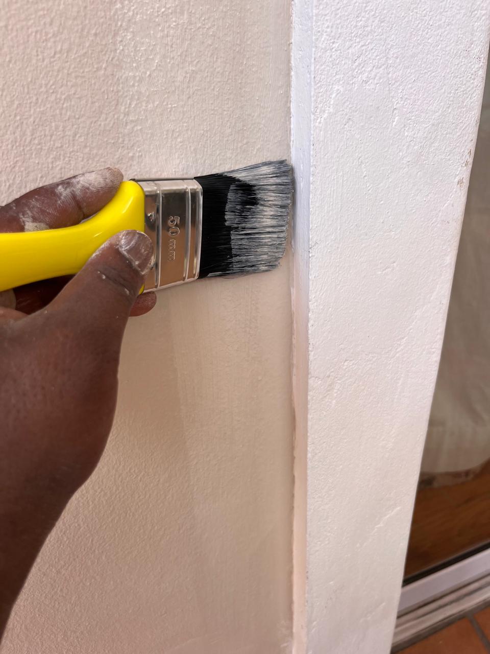 Precision brush painting on door frame — interior painting